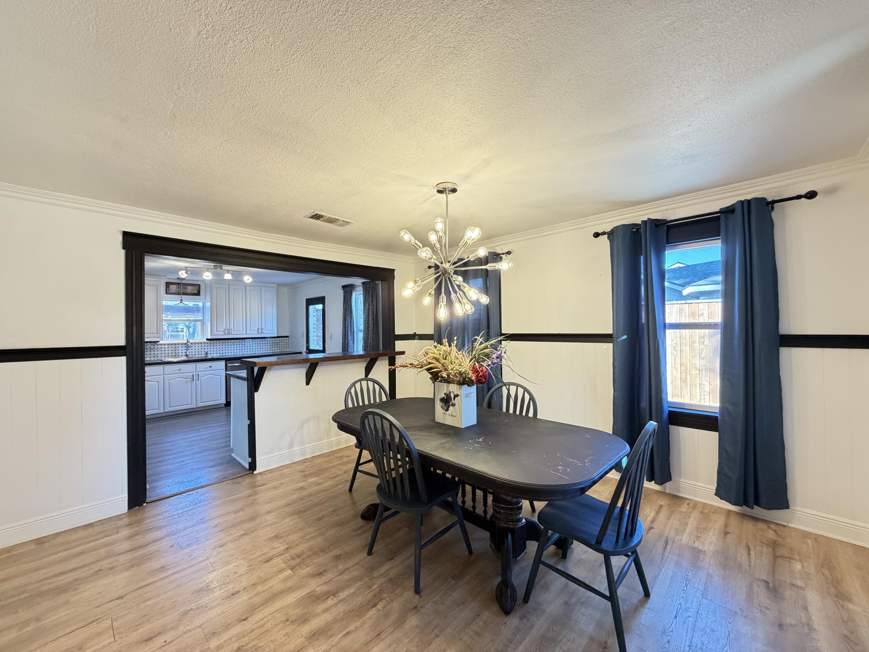 209 East 15th Street Littlefield, TX 79339 - Photo 5 of 18 a view of a dining room with furniture and a wooden floor