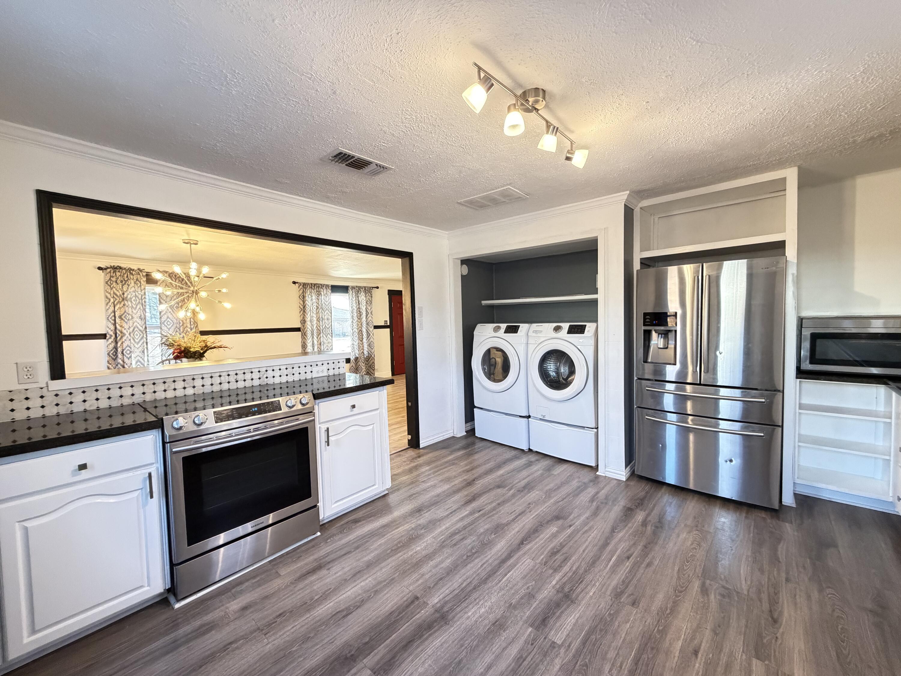 209 East 15th Street Littlefield, TX 79339 - Photo 7 of 18 a kitchen with stainless steel appliances granite countertop a stove and a refrigerator