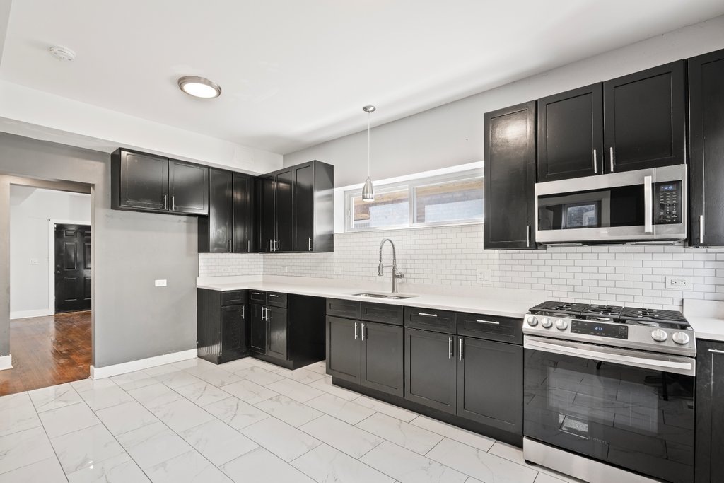 8014 South May Street Chicago, IL 60620 - Photo 12 of 50 a kitchen with stainless steel appliances a sink stove and refrigerator