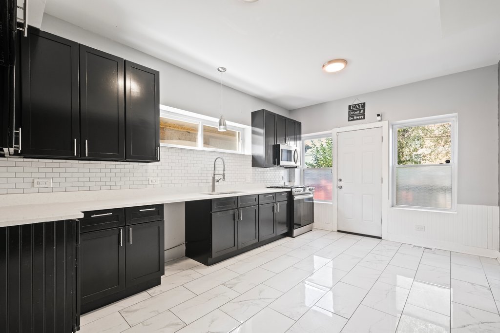 8014 South May Street Chicago, IL 60620 - Photo 14 of 50 a kitchen with stainless steel appliances a sink stove and cabinets