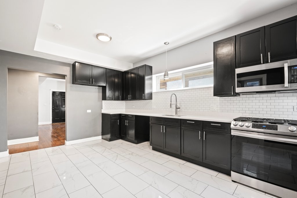 8014 South May Street Chicago, IL 60620 - Photo 16 of 50 a kitchen with stainless steel appliances granite countertop a refrigerator and a stove top oven