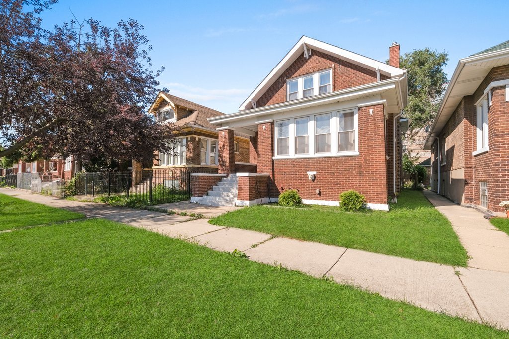 8014 South May Street Chicago, IL 60620 - Photo 2 of 50 a front view of a house with a garden and plants