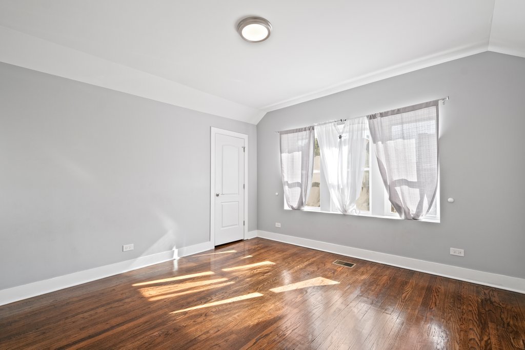 8014 South May Street Chicago, IL 60620 - Photo 27 of 50 an empty room with wooden floor and windows