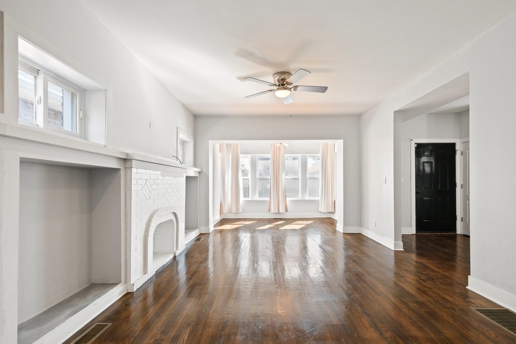 8014 South May Street Chicago, IL 60620 - Photo 3 of 50 a view of an empty room with a window and wooden floor