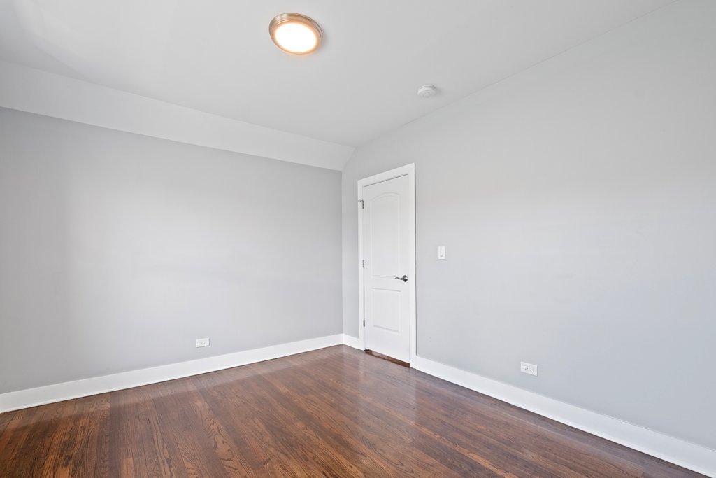 8014 South May Street Chicago, IL 60620 - Photo 31 of 50 a view of an empty room with wooden floor