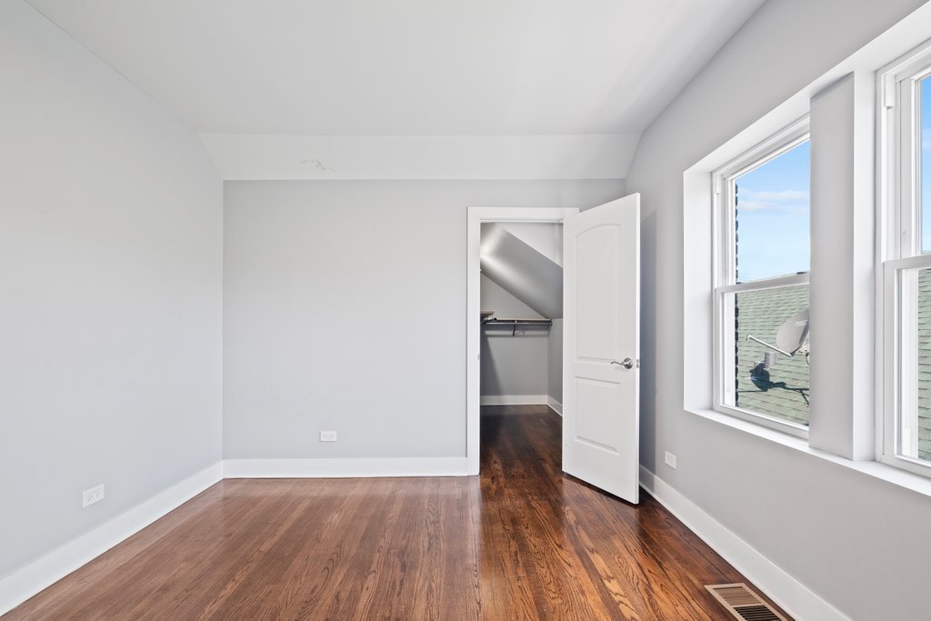 8014 South May Street Chicago, IL 60620 - Photo 32 of 50 a view of empty room with wooden floor and fan