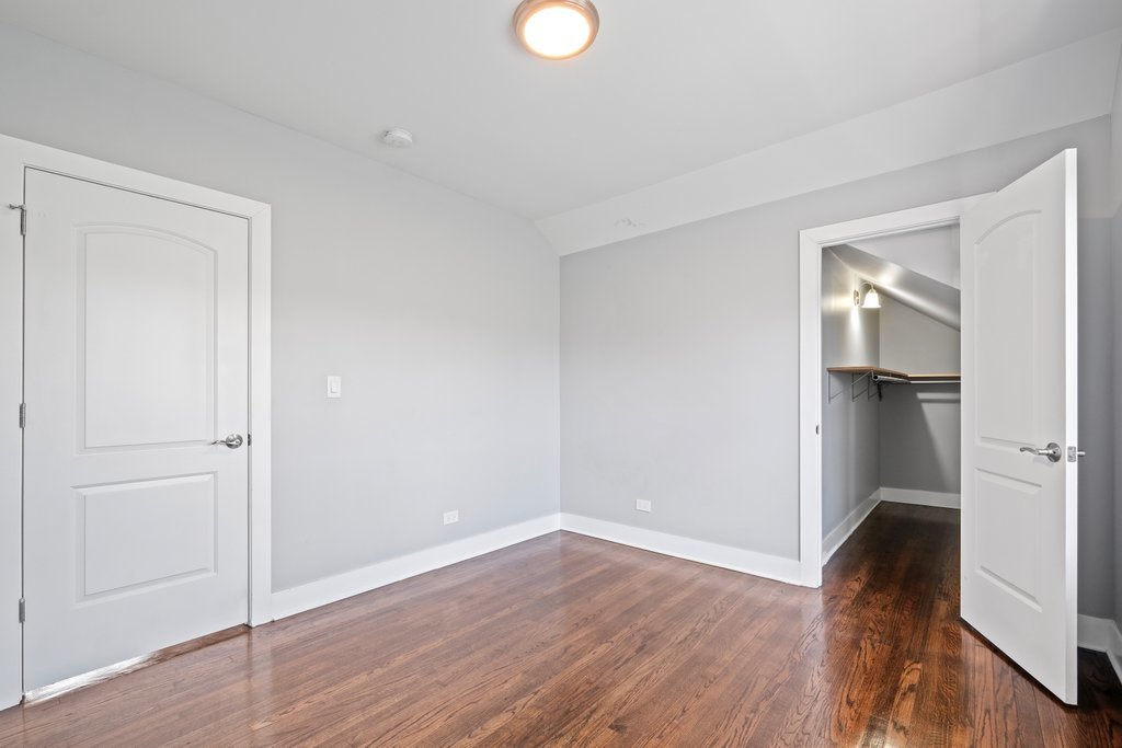 8014 South May Street Chicago, IL 60620 - Photo 36 of 50 a view of empty room with wooden floor and fan