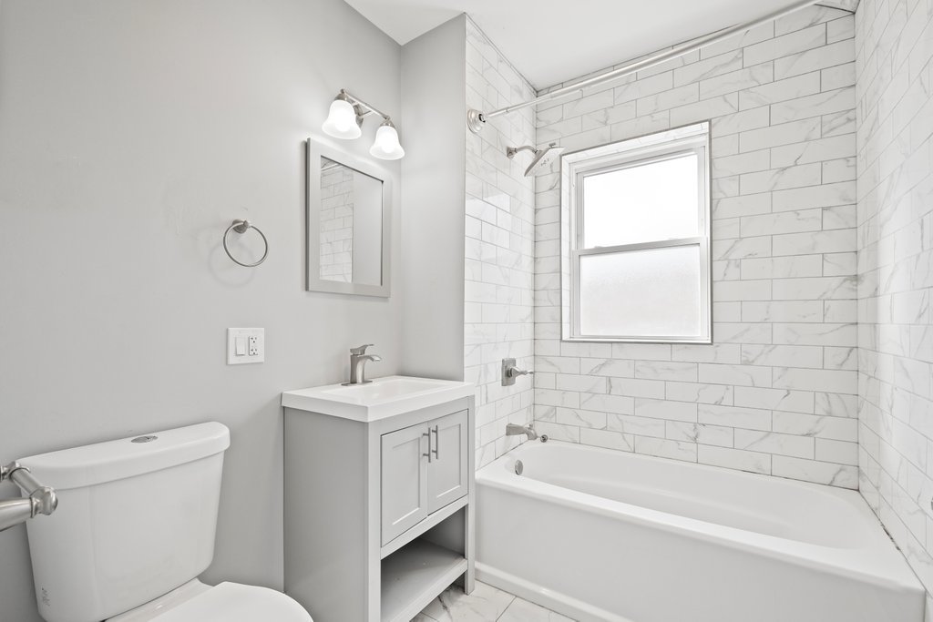 8014 South May Street Chicago, IL 60620 - Photo 38 of 50 a bathroom with a sink a toilet and a bathtub