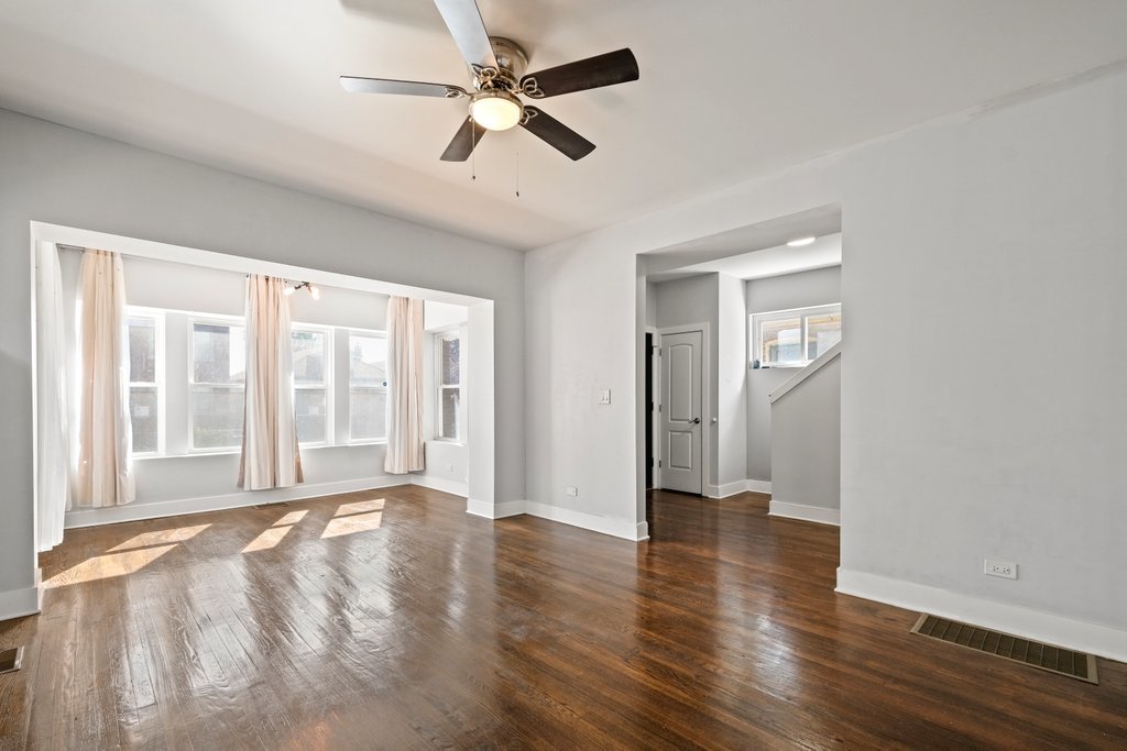 8014 South May Street Chicago, IL 60620 - Photo 4 of 50 an empty room with wooden floor fan and windows