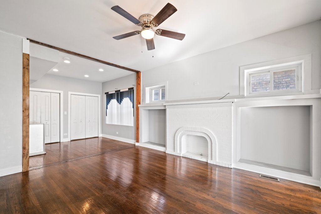 8014 South May Street Chicago, IL 60620 - Photo 7 of 50 a view of a livingroom with a fireplace a ceiling fan and wooden floor