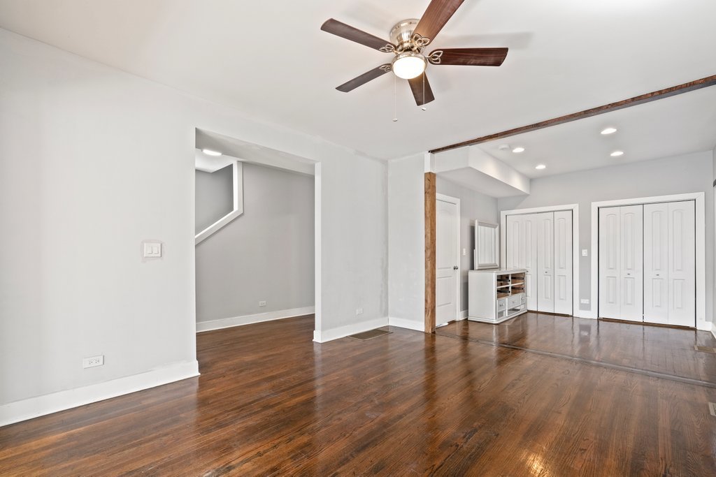 8014 South May Street Chicago, IL 60620 - Photo 8 of 50 a view of an empty room with wooden floor and a ceiling fan