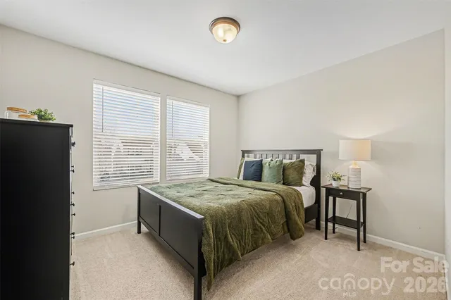 a view of a bedroom with baby crib and lounge chair