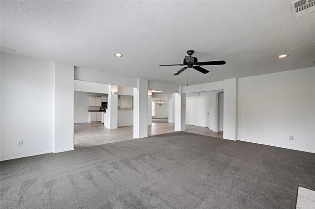 a view of empty room with wooden floor and ceiling fan