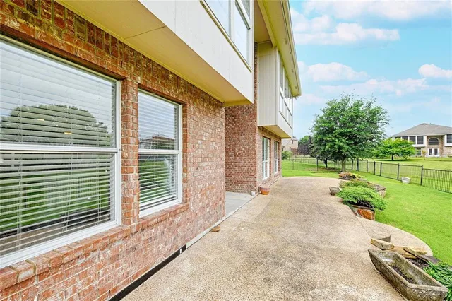a view of a backyard with plants and brick wall