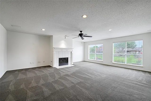 a view of an empty room with a fireplace and a window
