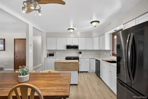a kitchen with stainless steel appliances granite countertop a sink refrigerator and microwave