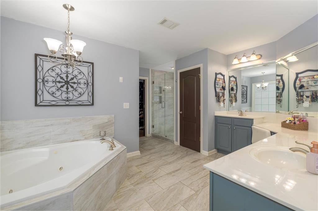 2016 Portage Point Southeast Lawrenceville, GA 30045 - Photo 11 of 44 a spacious bathroom with a bathtub sink and a mirror