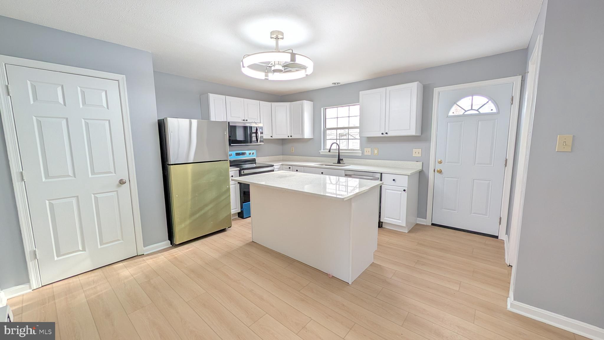 354 Valley Mill Road Winchester, VA 22602 - Photo 3 of 34 a kitchen with a refrigerator a sink and dishwasher with wooden floor