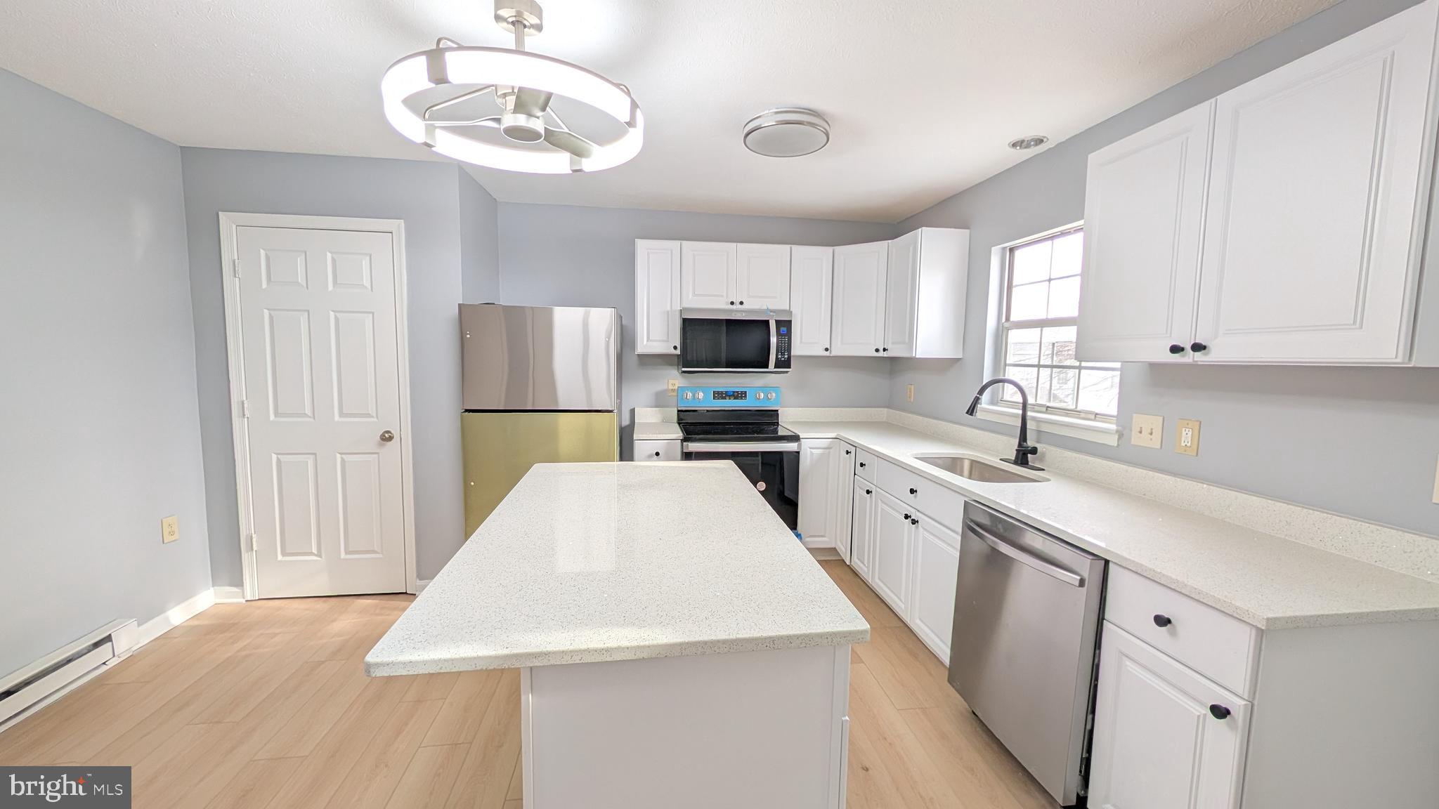 354 Valley Mill Road Winchester, VA 22602 - Photo 4 of 34 a kitchen with a sink a microwave a refrigerator and cabinets