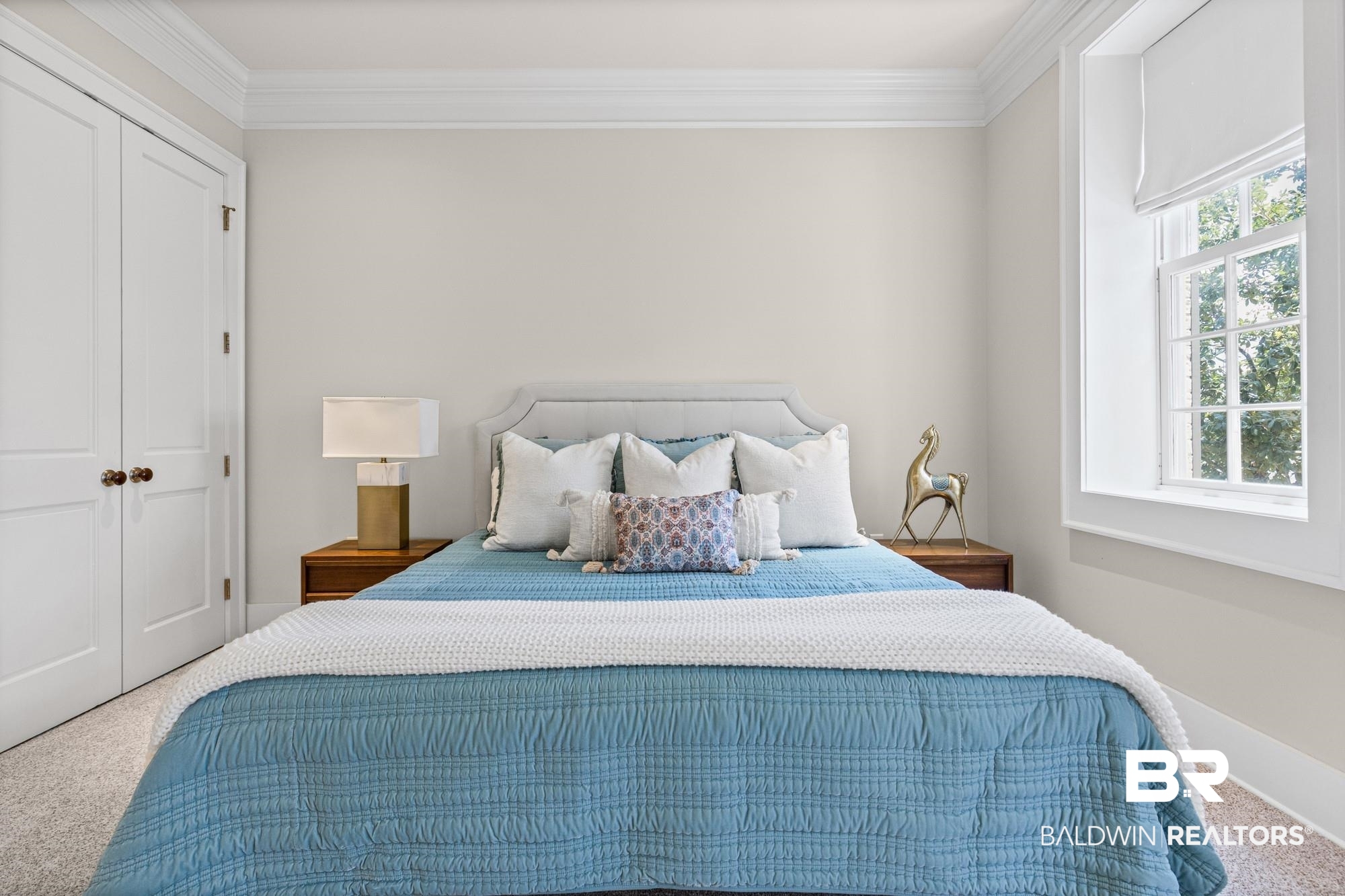 701 Dauphin Street, Unit A Mobile, AL 36602 - Photo 24 of 31 Bedroom featuring an upholstered headboard, dual bedside tables, carpet flooring, a multi-pane window, and a double-door closet