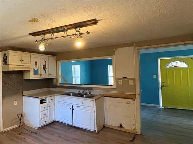 a kitchen with cabinets and wooden floor