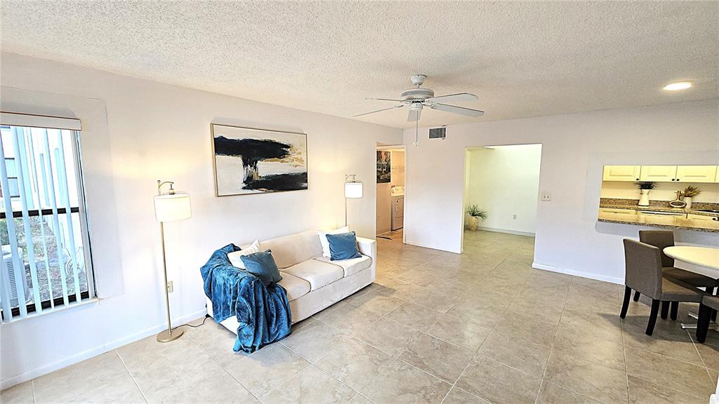 1109 Pine Ridge Circle West, Unit C1 Tarpon Springs, FL 34688 - Photo 14 of 50 a living room with furniture and a large window