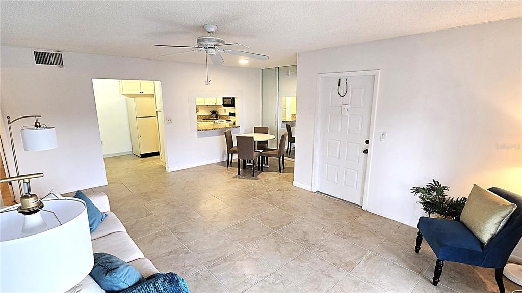 1109 Pine Ridge Circle West, Unit C1 Tarpon Springs, FL 34688 - Photo 15 of 50 a living room with furniture and a chandelier