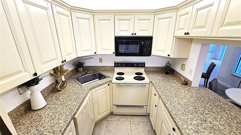 1109 Pine Ridge Circle West, Unit C1 Tarpon Springs, FL 34688 - Photo 19 of 50 a kitchen with a stove a sink and a refrigerator