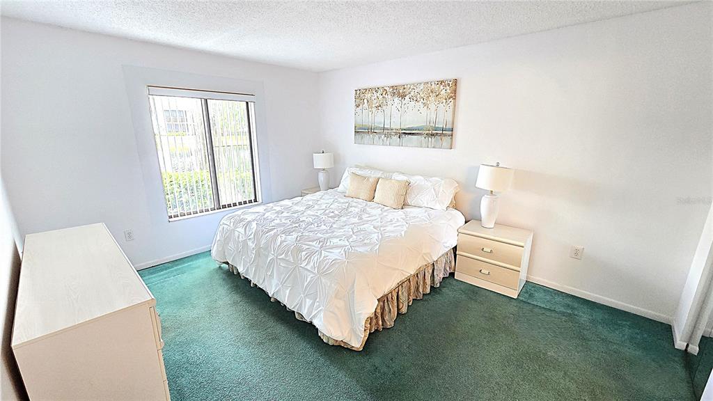 1109 Pine Ridge Circle West, Unit C1 Tarpon Springs, FL 34688 - Photo 25 of 50 a bed sitting in a bedroom next to a window
