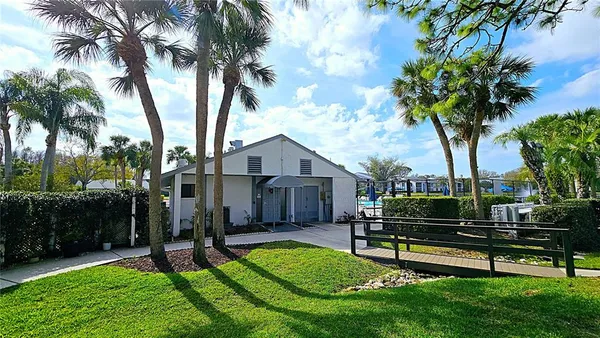 a view of a house with garden and a tree