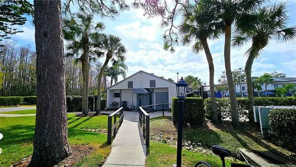 a front view of a house with a yard and dinning table under an umbrella