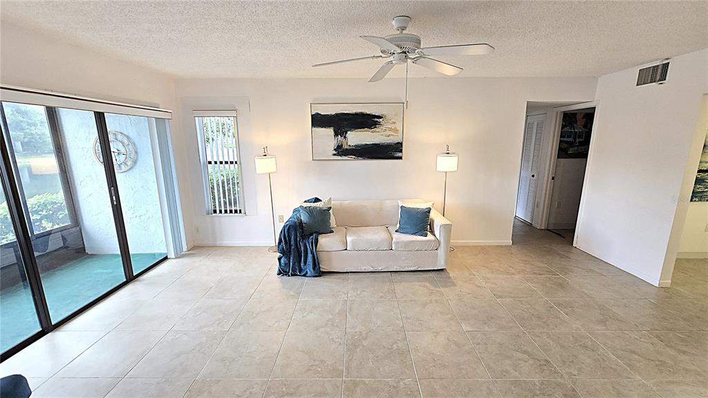 1109 Pine Ridge Circle West, Unit C1 Tarpon Springs, FL 34688 - Photo 7 of 50 a living room with furniture and a flat screen tv
