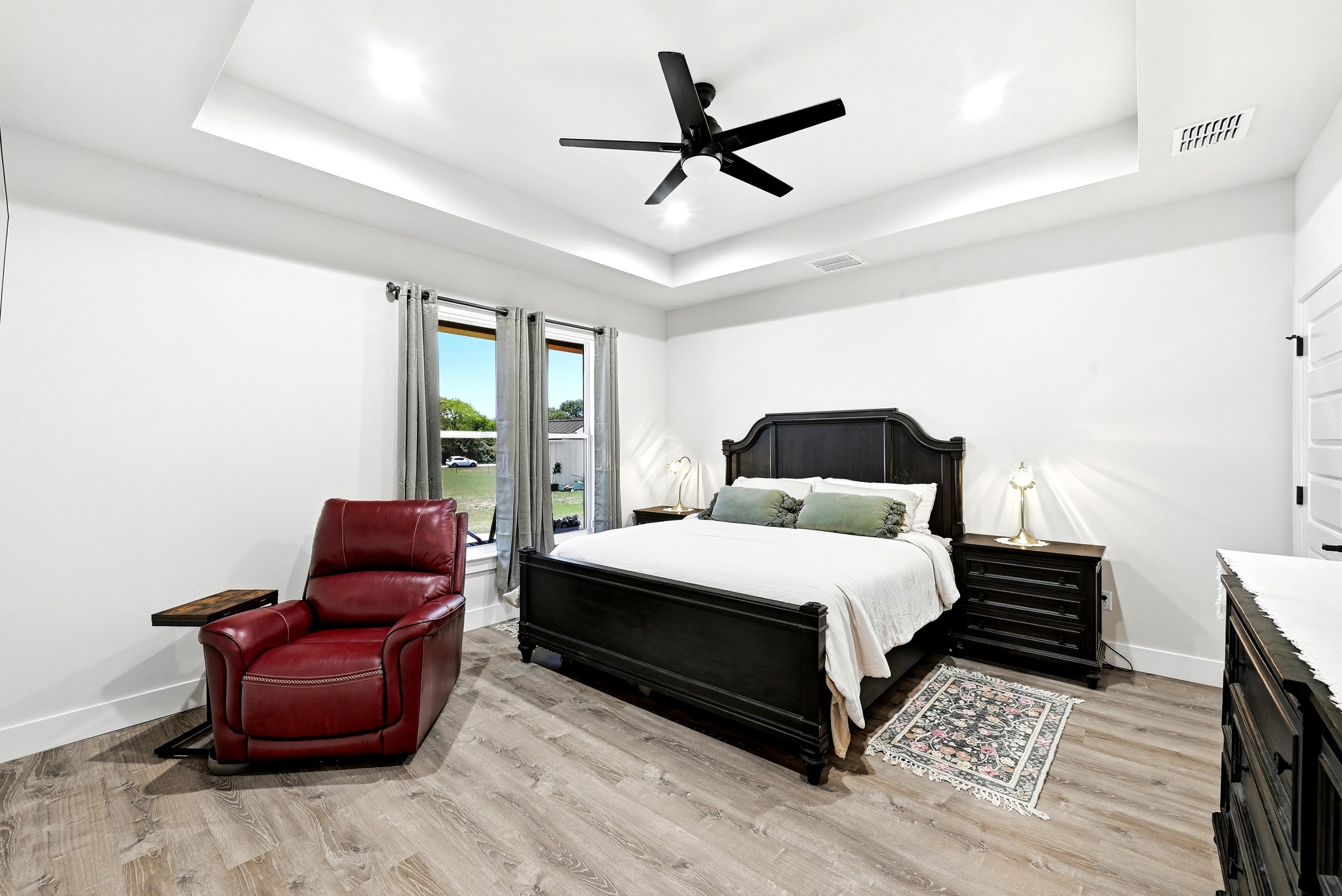 2889 Old McMahan Road Lockhart, TX 78644 - Photo 19 of 33 Recessed lighting and a modern ceiling fan illuminate this spacious bedroom with tray ceilings.