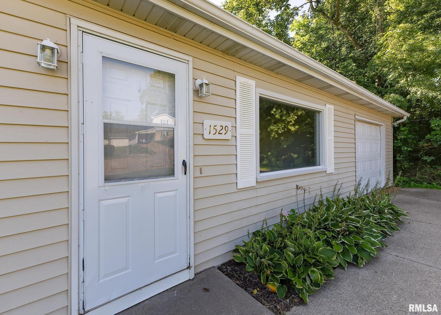 1529 North 8th Street Clinton, IA 52732 - Photo 2 of 15 a front view of a house with a flower garden