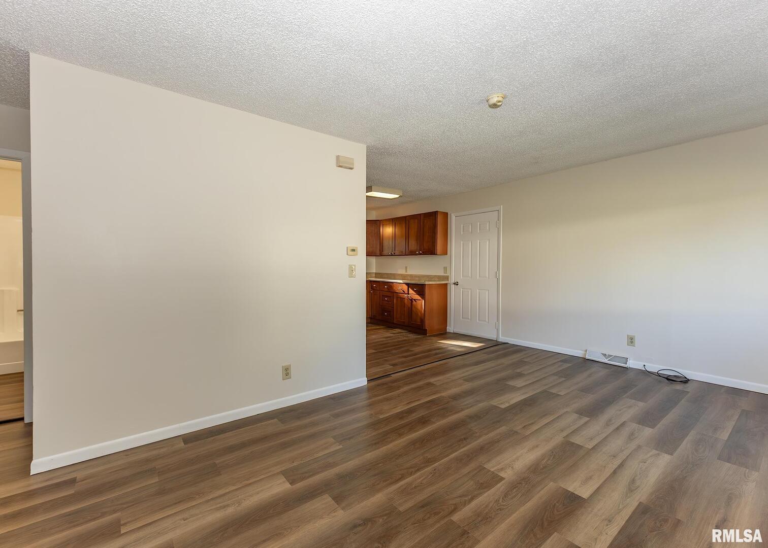 1529 North 8th Street Clinton, IA 52732 - Photo 3 of 15 a view of empty room with wooden floor and kitchen