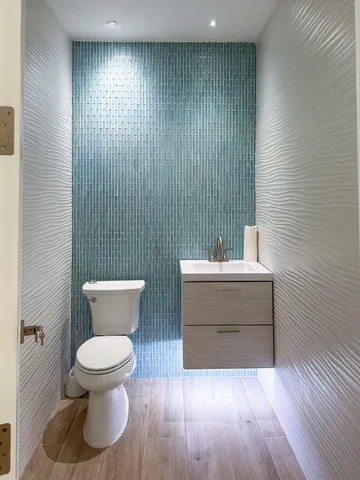 a bathroom with a toilet a sink and mirror