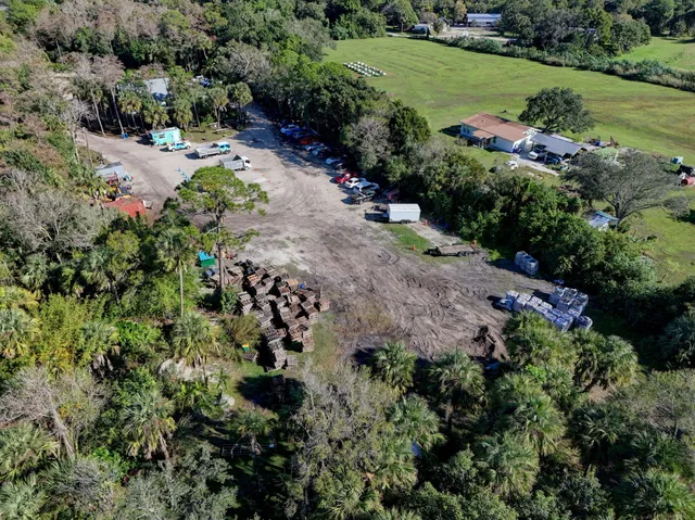 an aerial view of residential house with outdoor space and trees all around