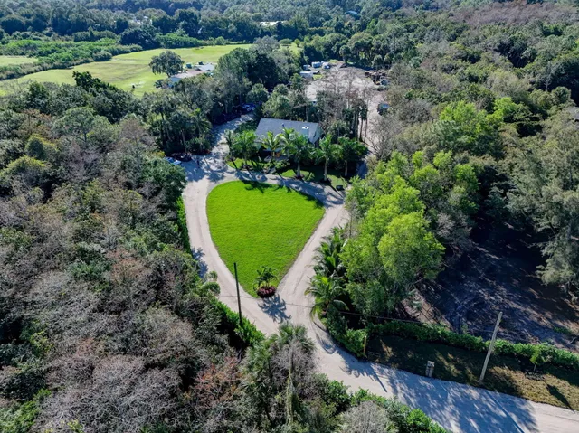 an aerial view of a house with a yard and lake view
