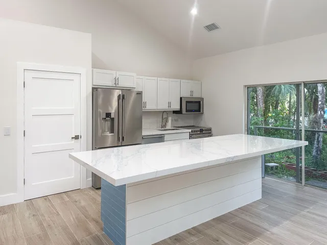 a large kitchen with a refrigerator a sink and a stove