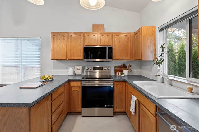 a kitchen with stainless steel appliances granite countertop a sink stove and cabinets