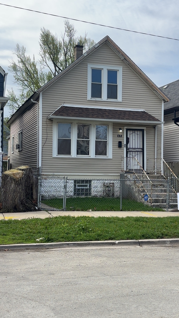 65 West 112th Place Chicago, IL 60628 - Photo 2 of 3 a front view of a house with a yard and garage
