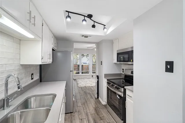 a kitchen with stainless steel appliances granite countertop a sink stove and refrigerator