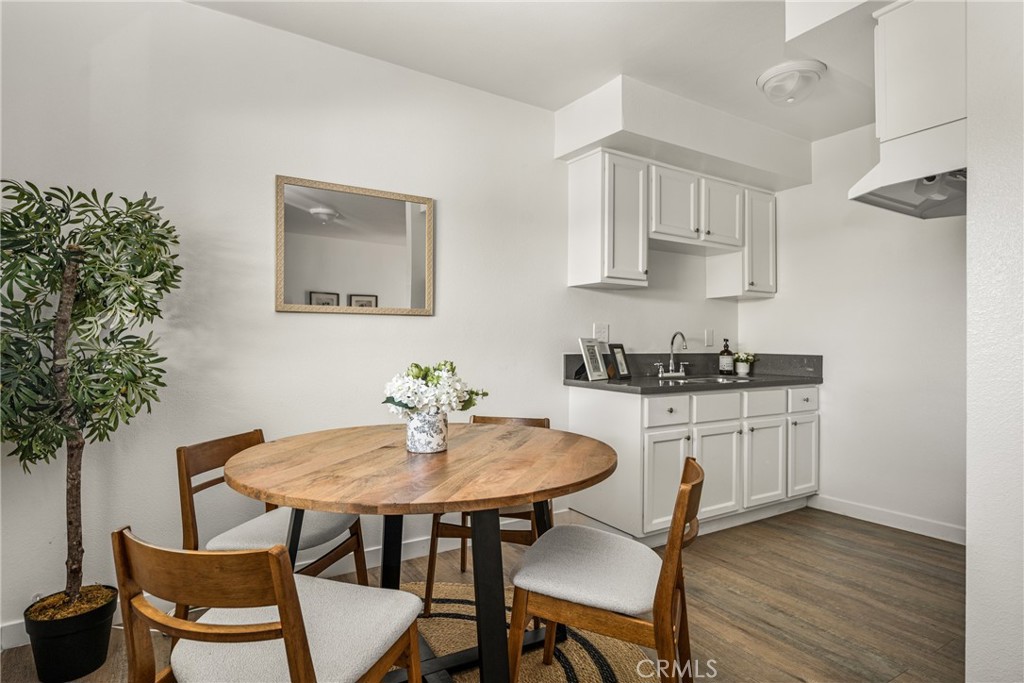 6725 Perry Road Bell Gardens, CA 90201 - Photo 21 of 40 a kitchen with stainless steel appliances a white table and chairs in it