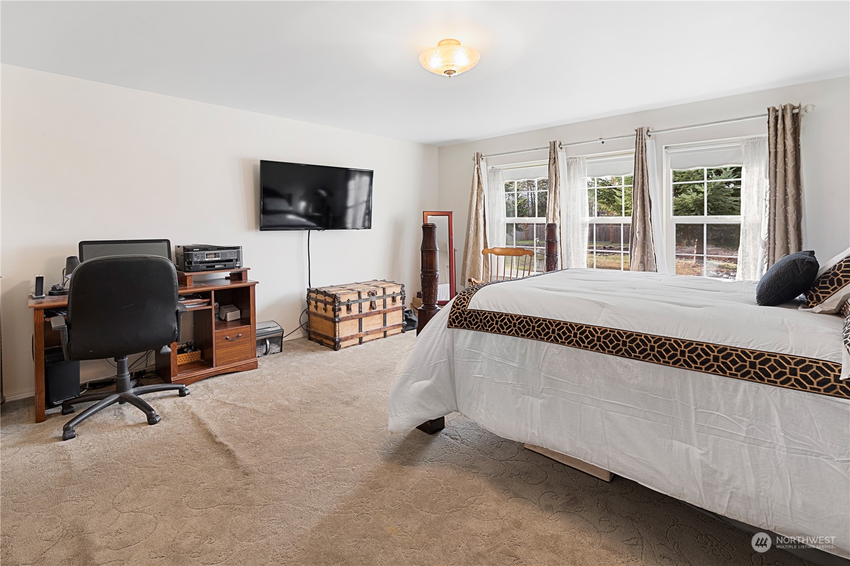 261 Chiesa Place Sequim, WA 98382 - Photo 16 of 39 a spacious bedroom with a bed and a flat screen tv