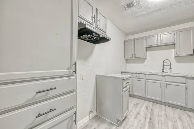 a kitchen with granite countertop cabinets stainless steel appliances and a sink