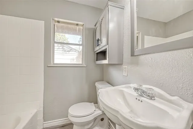 a bathroom with a sink a toilet and a mirror