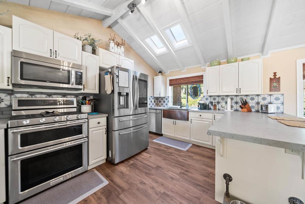 1569 Vía Monserate Fallbrook, CA 92028 - Photo 13 of 75 a kitchen with stainless steel appliances and stove top oven