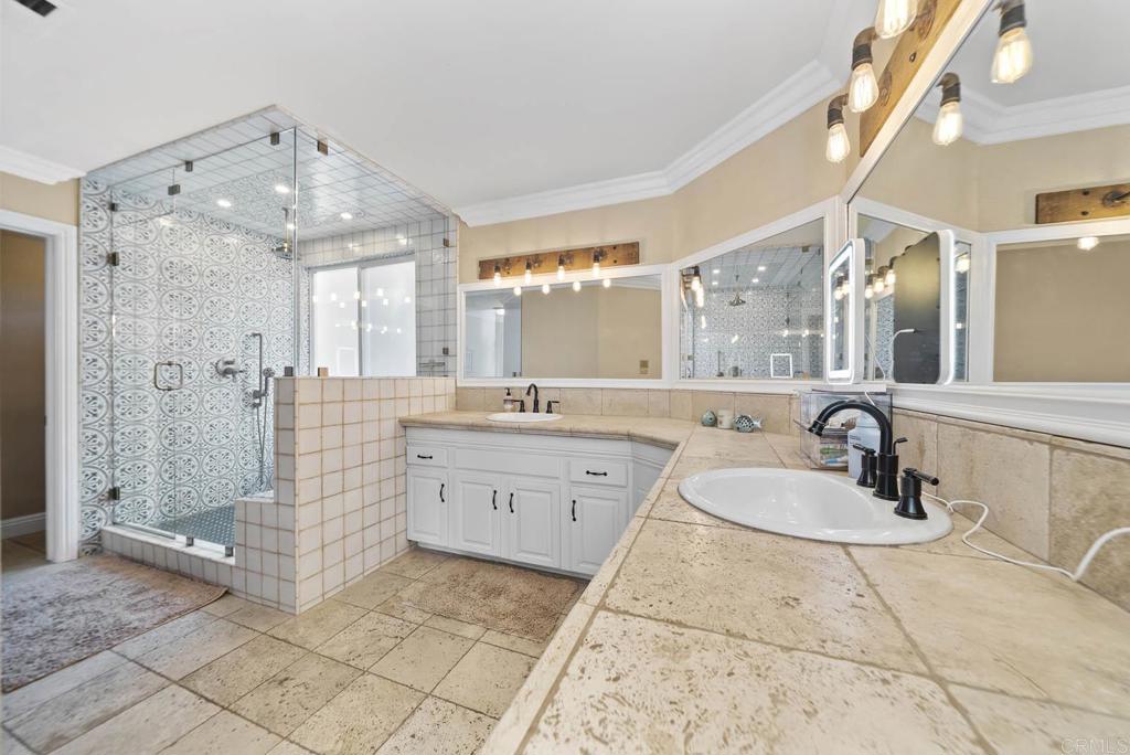 1569 Vía Monserate Fallbrook, CA 92028 - Photo 28 of 75 a spacious bathroom with a double vanity sink mirror and shower
