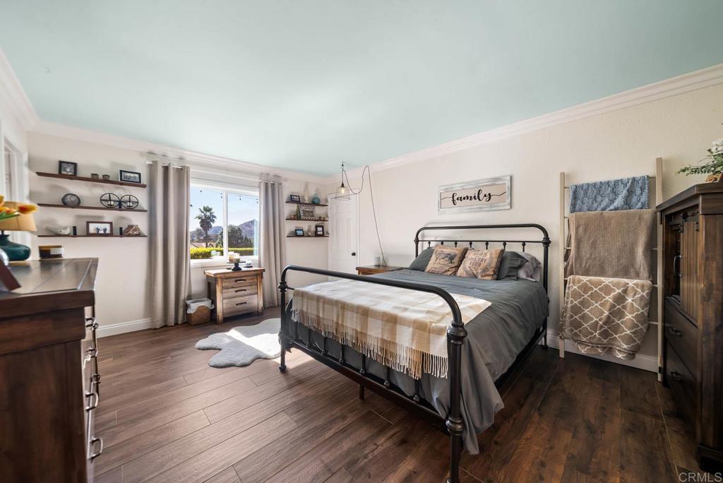 1569 Vía Monserate Fallbrook, CA 92028 - Photo 32 of 75 a bedroom with a bed and a wooden floor
