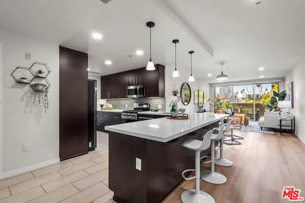 a kitchen with stainless steel appliances granite countertop a sink a stove and a refrigerator